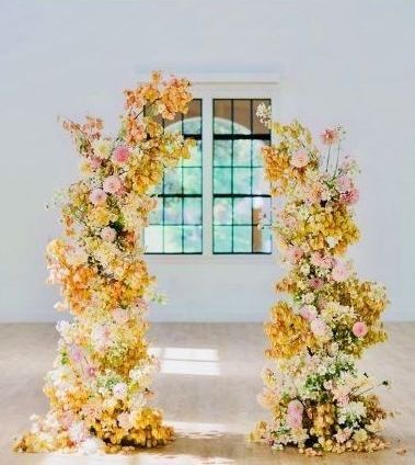 a beautiful arch with yellow, pink and cream florals